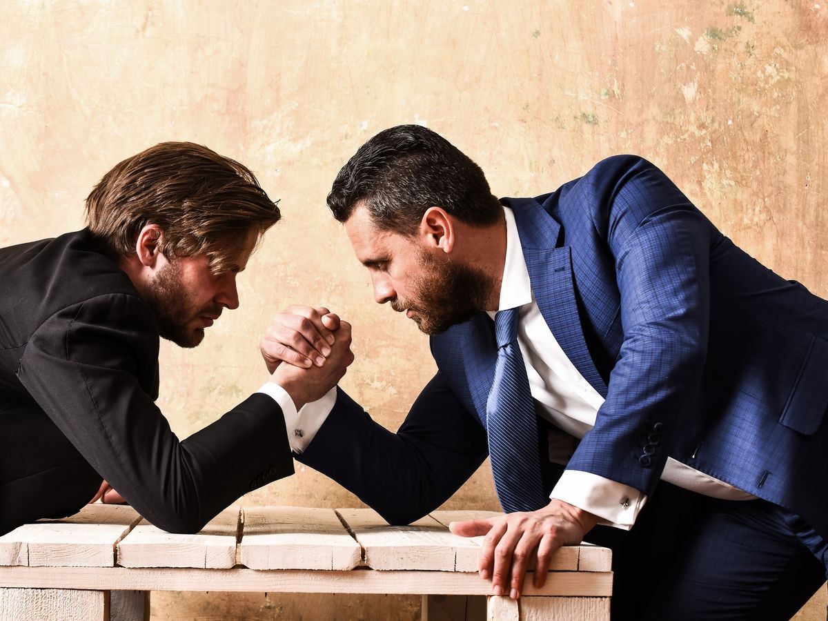 opposition of businessmen or men in suit, arm wrestling and power, business situation